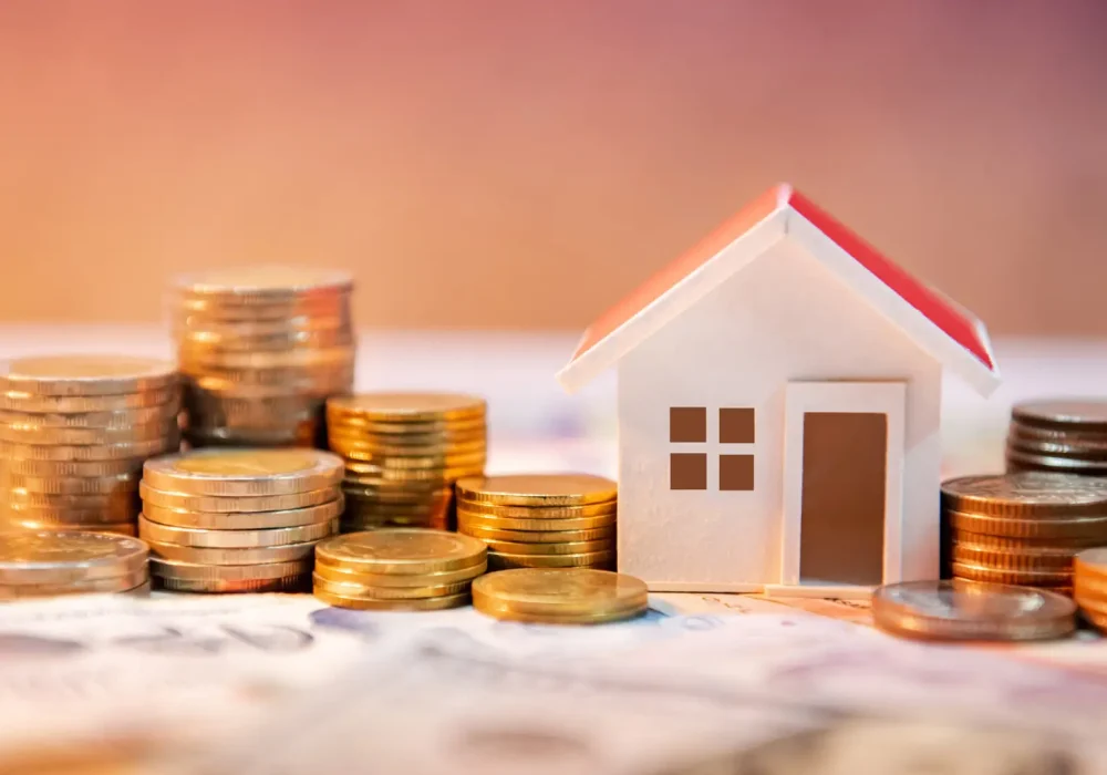 Real estate or property investment. Home mortgage loan rate. Saving money for retirement concept. Coin stack on international banknotes with house model on table. Business growth background Real estate or property investment. Home mortgage loan rate. Saving money for retirement concept. Coin stack on international banknotes with house model on table. Business growth background